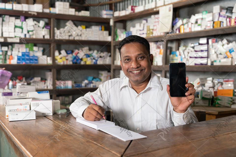 A male of village pharmacy checking online orders