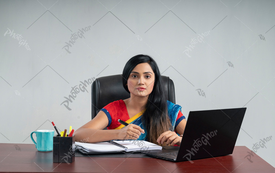 Bangladeshi business woman working in internet sit at office desk