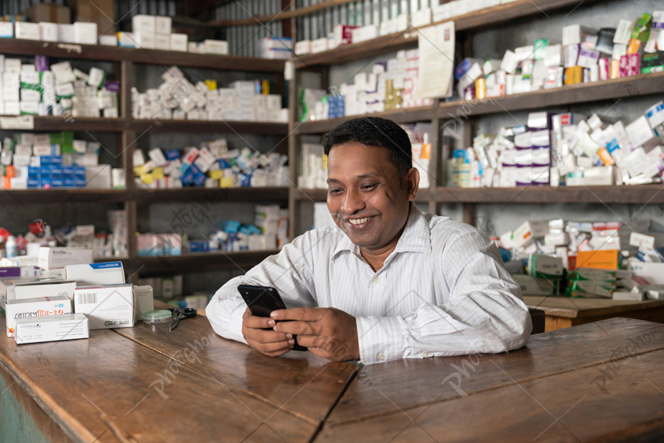 Bangladeshi pharmacist using mobile to checking online