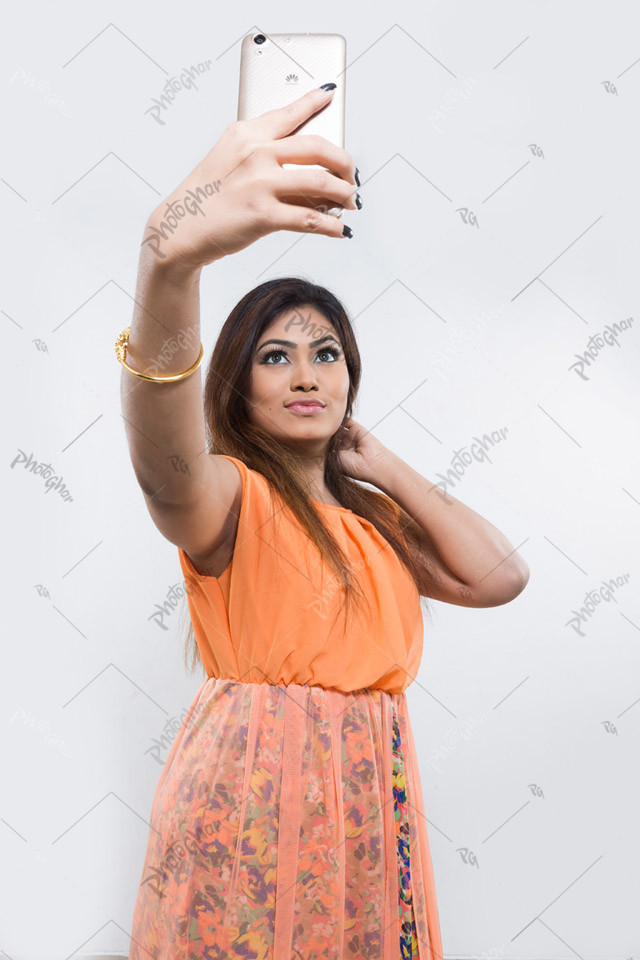 Bangladeshi woman holding smartphone to taking selfie