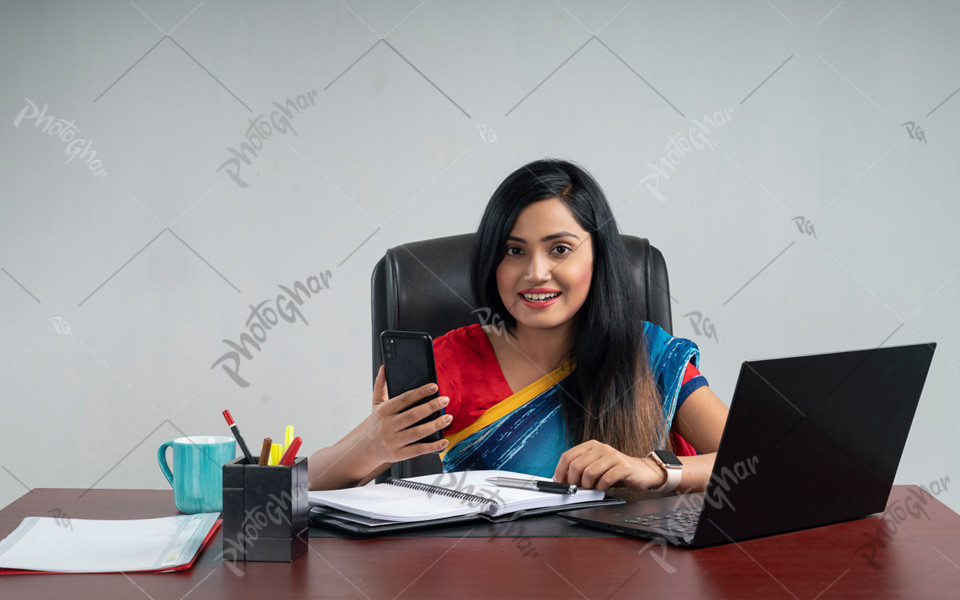 Beautiful female employee typing on laptop