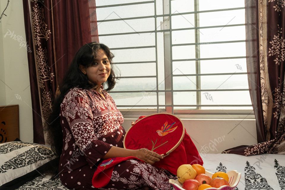 Beautiful pregnant woman in Bangladesh knitting