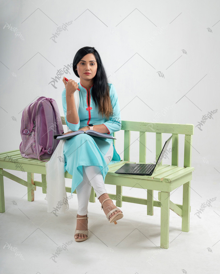 Beautiful young student sitting on bench