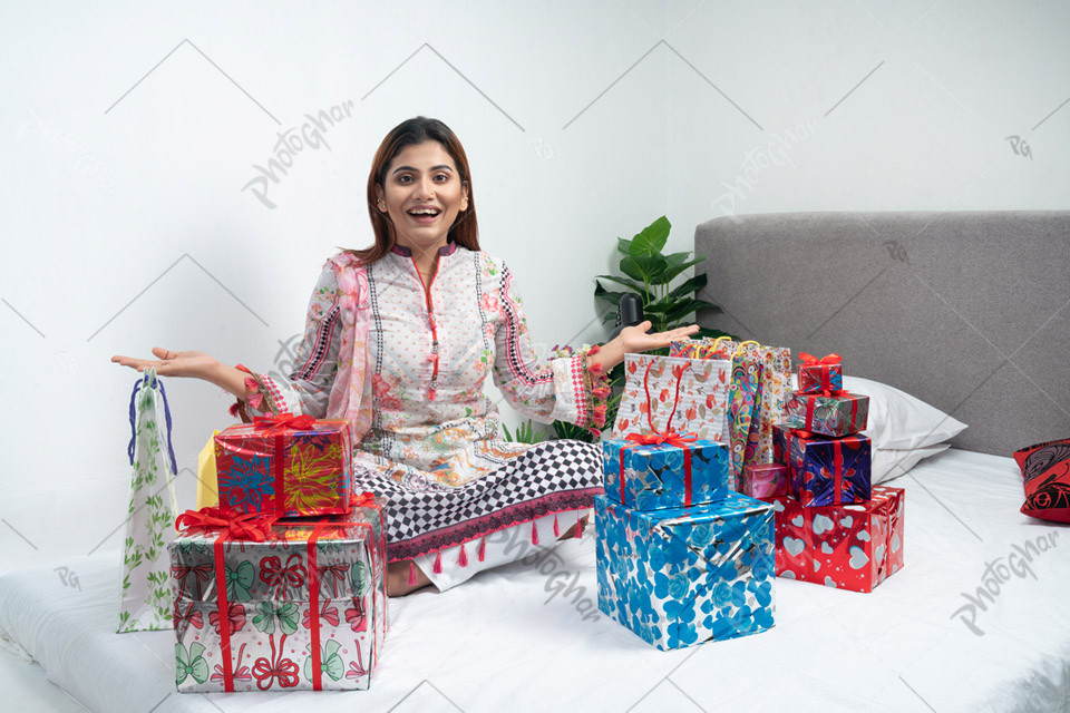 Cheerful shocked housewife showing gift boxes