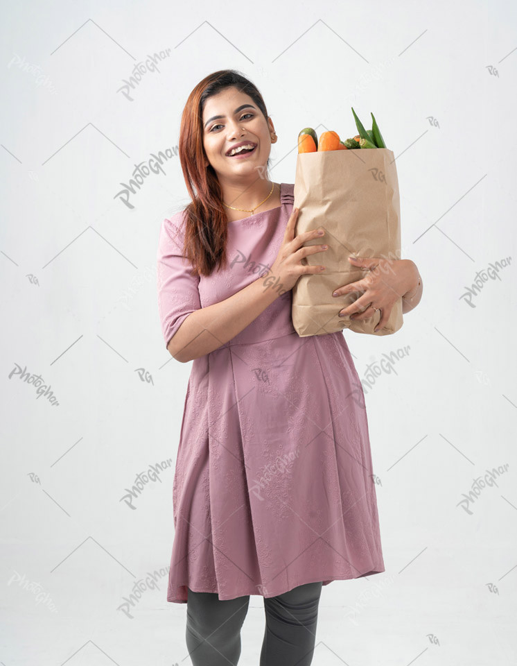 Cheerful shopping housewife holding paper bag