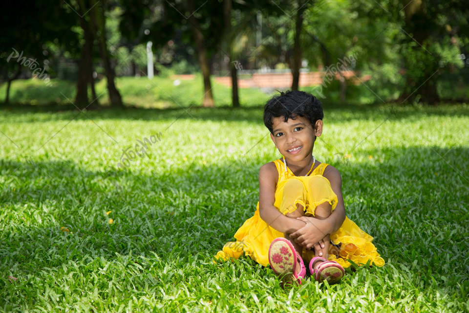 Child sitting on green grass