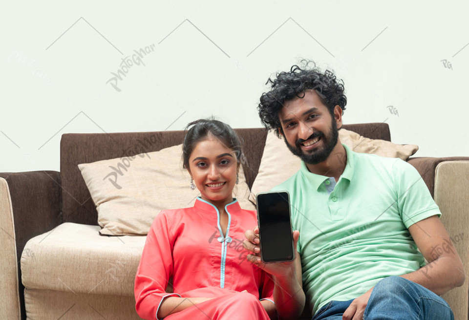 Confident smiling couple showing smartphone