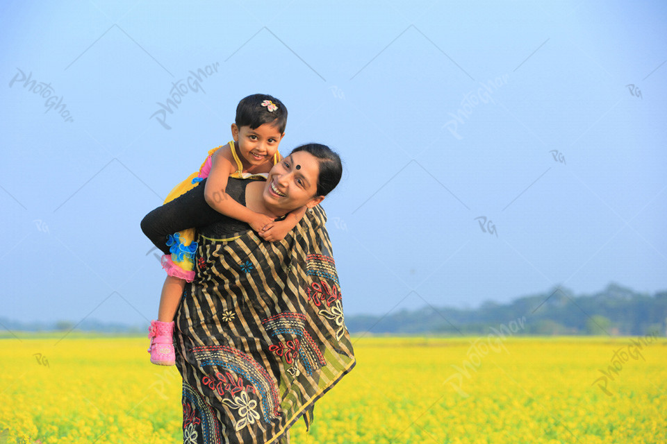 Cute young daughter on a piggy back ride with her mother