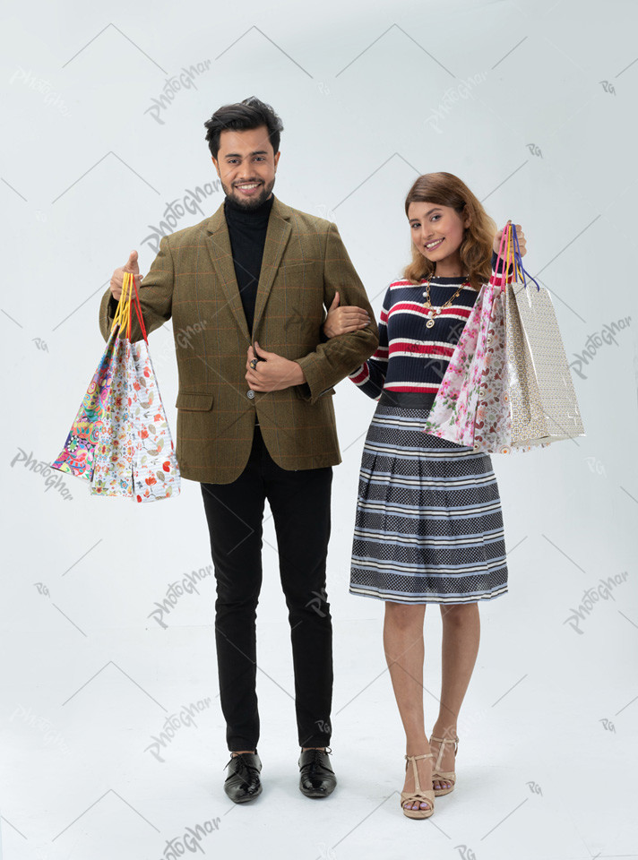 Delightful young couple holding bags