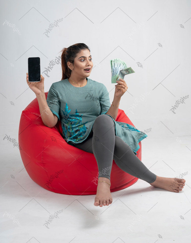 Excited woman of South asian holding banknotes