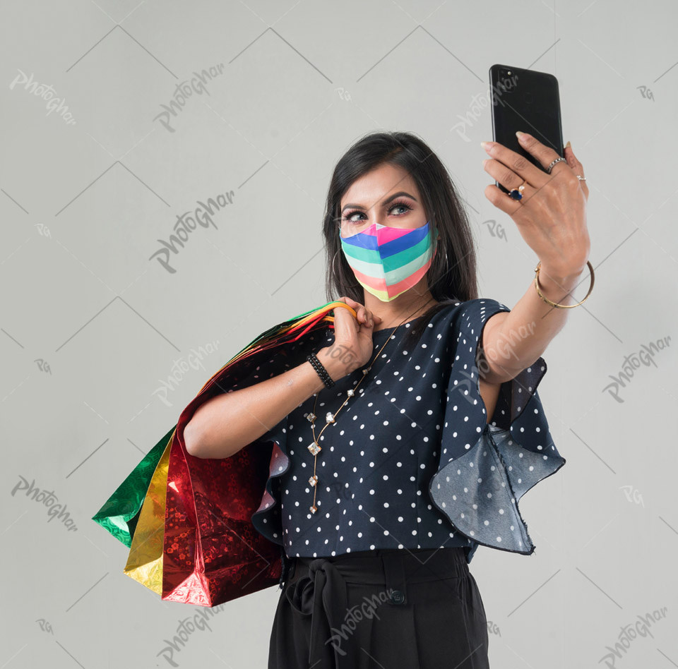 Female customer in medical protective mask taking selfie