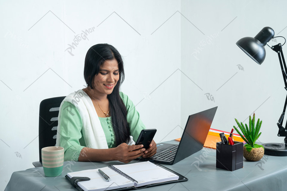 Female executive officer using smartphone in office