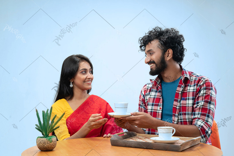 Happy boyfriend giving cup tea girlfriend