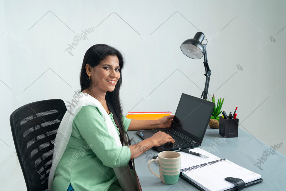 Happy businesswoman working on laptop