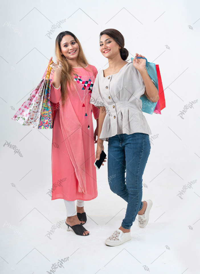 Happy girls friends holding shopping bags