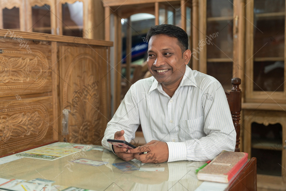 Happy smiling salesman in village furniture store