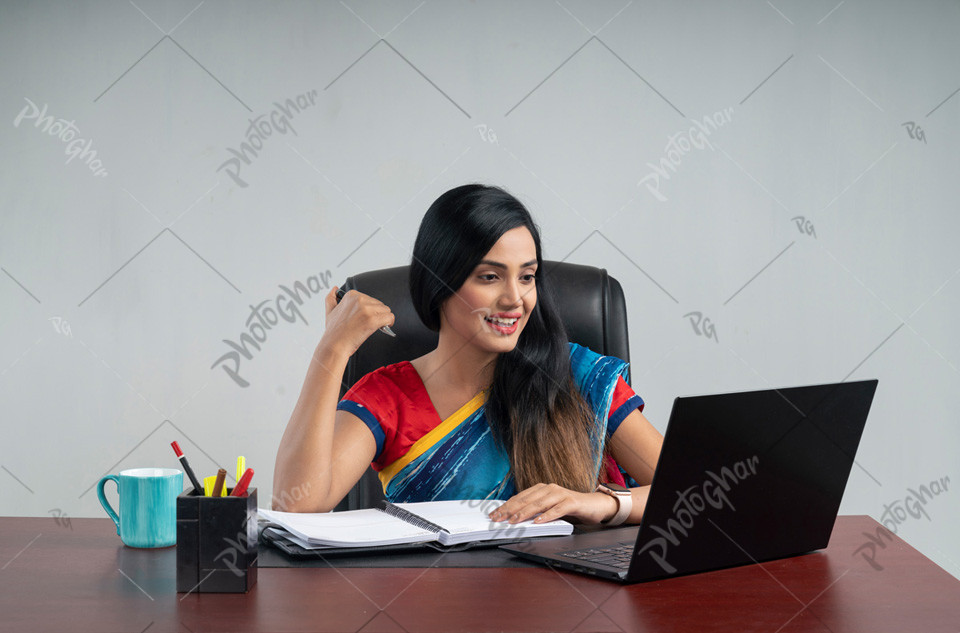 Happy young Bangladeshi businesswoman using computer