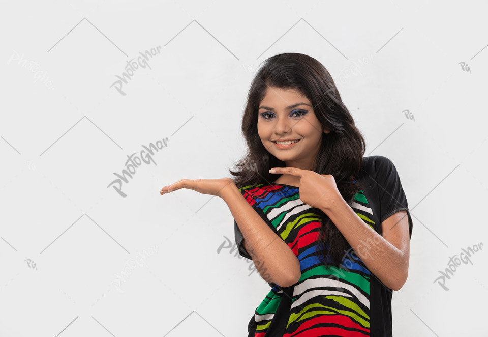 Happy young girl pointing to the empty area