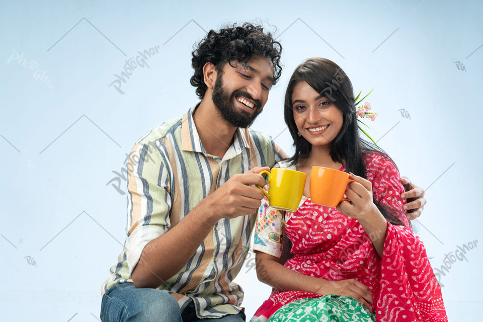 Joyful couple holding coffee mugs