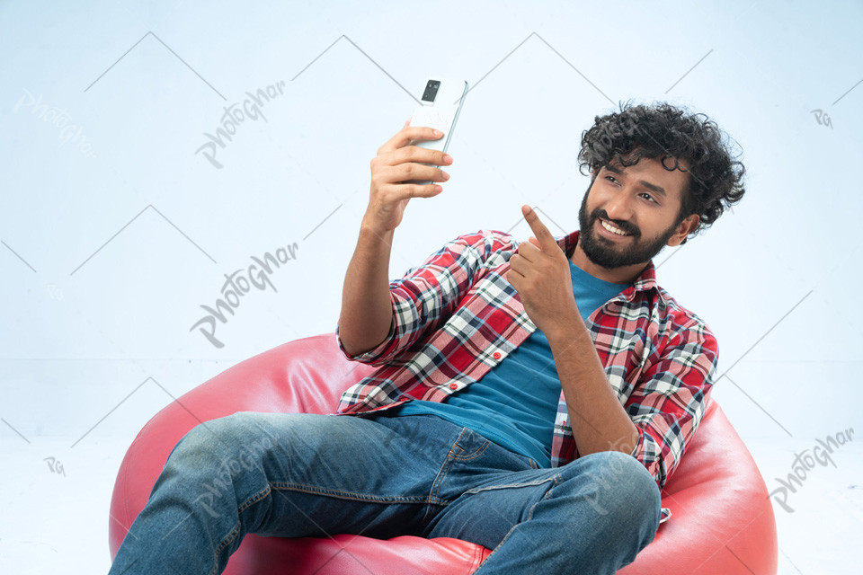 Joyful fashionable man taking selfie