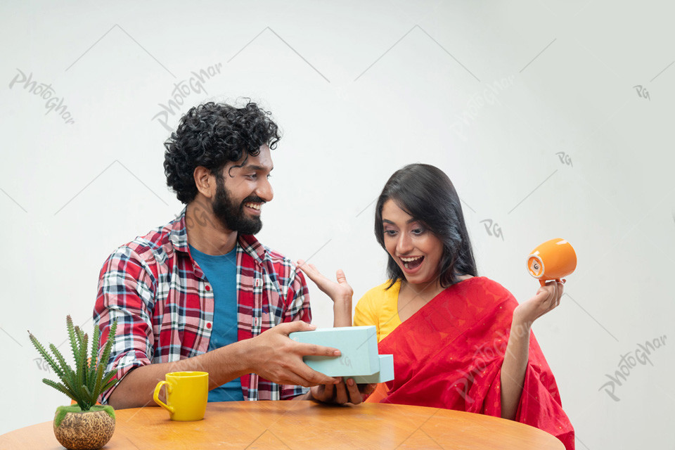 Joyful man presents gift box to shoked woman