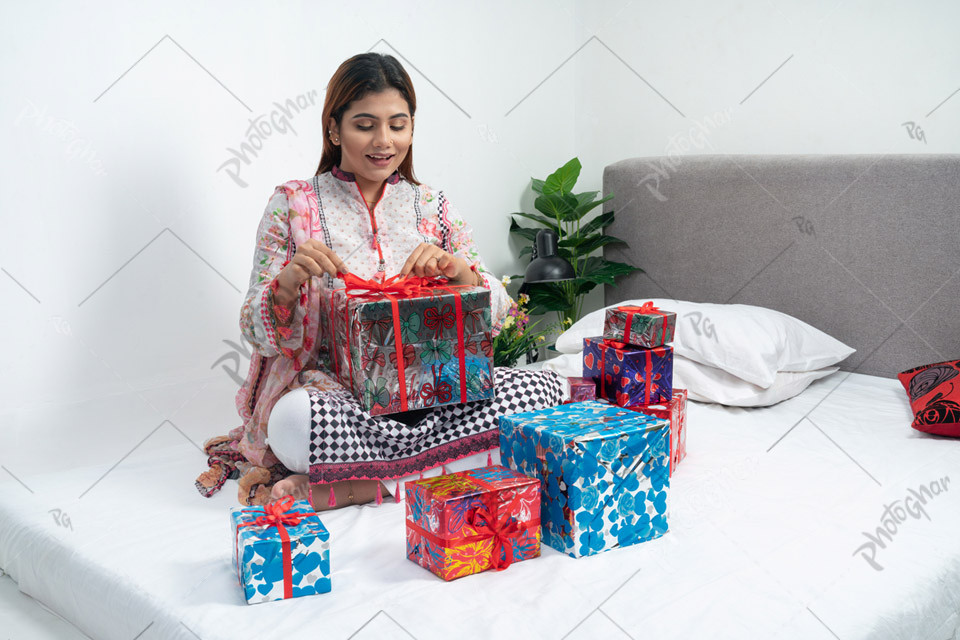 Joyful woman sitting with gift boxes