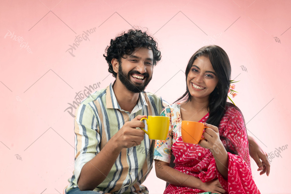 Laughing couple holding coffee mugs