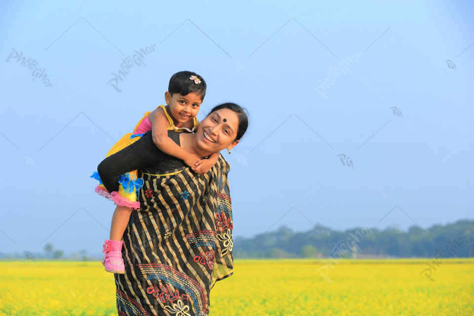 Mother carrying daughter on her shoulders