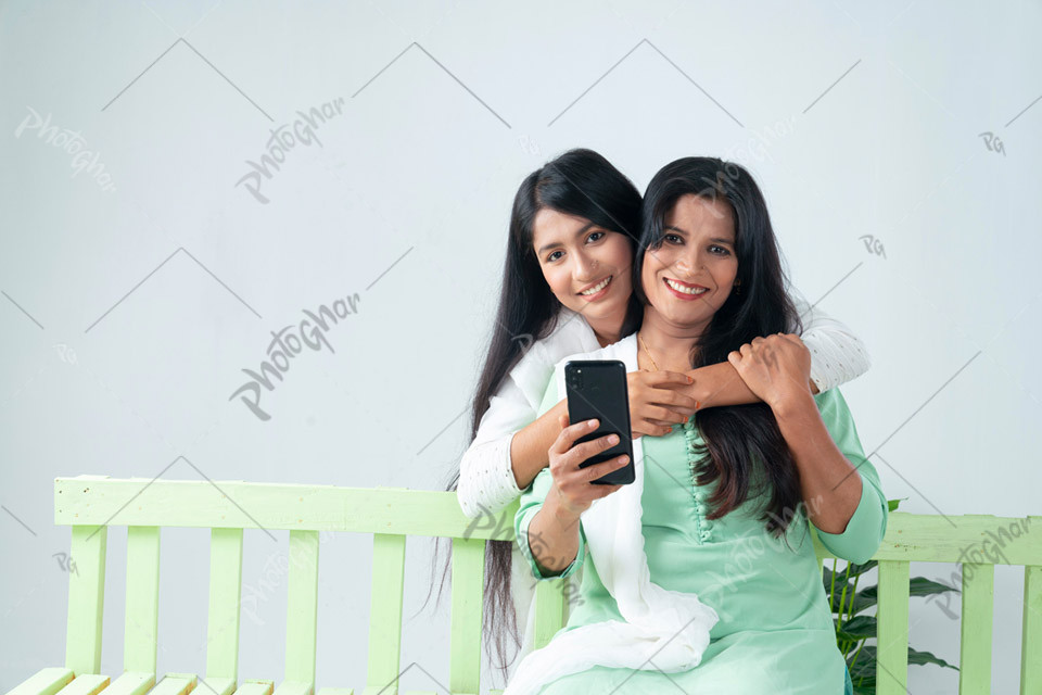 Mother teenage daughter using smartphone