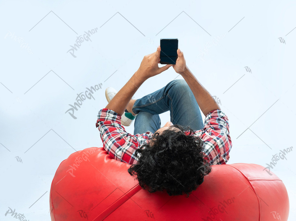 Over shoulder view of man lying on bean bag