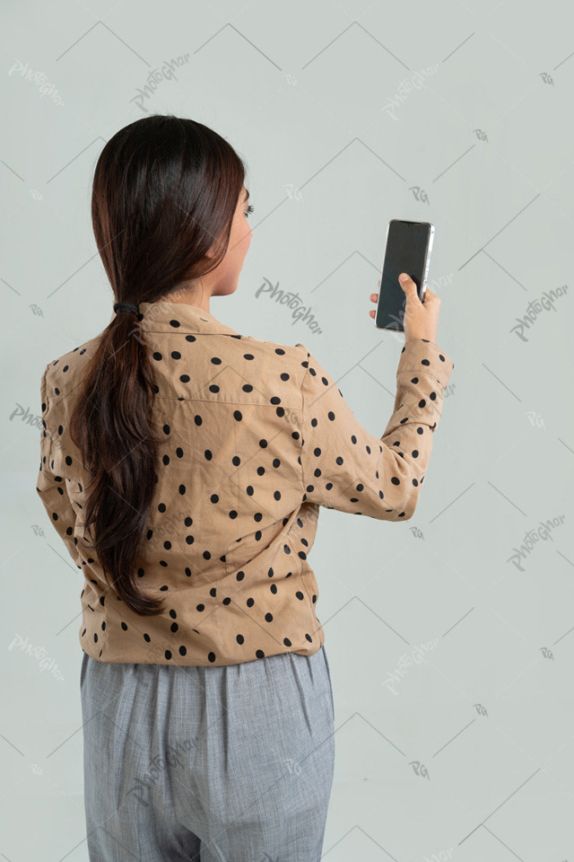 Over shoulder view of woman looking at mobile screen