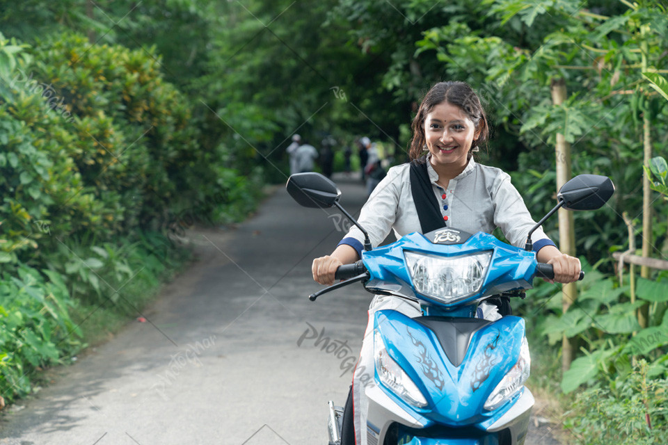 Portrait of a happy Asian Beautiful girl riding on scooty