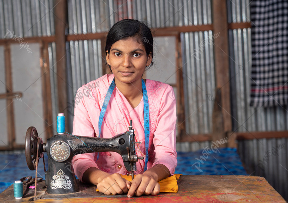 Portrait of beautiful girl sewing on a sewing machine