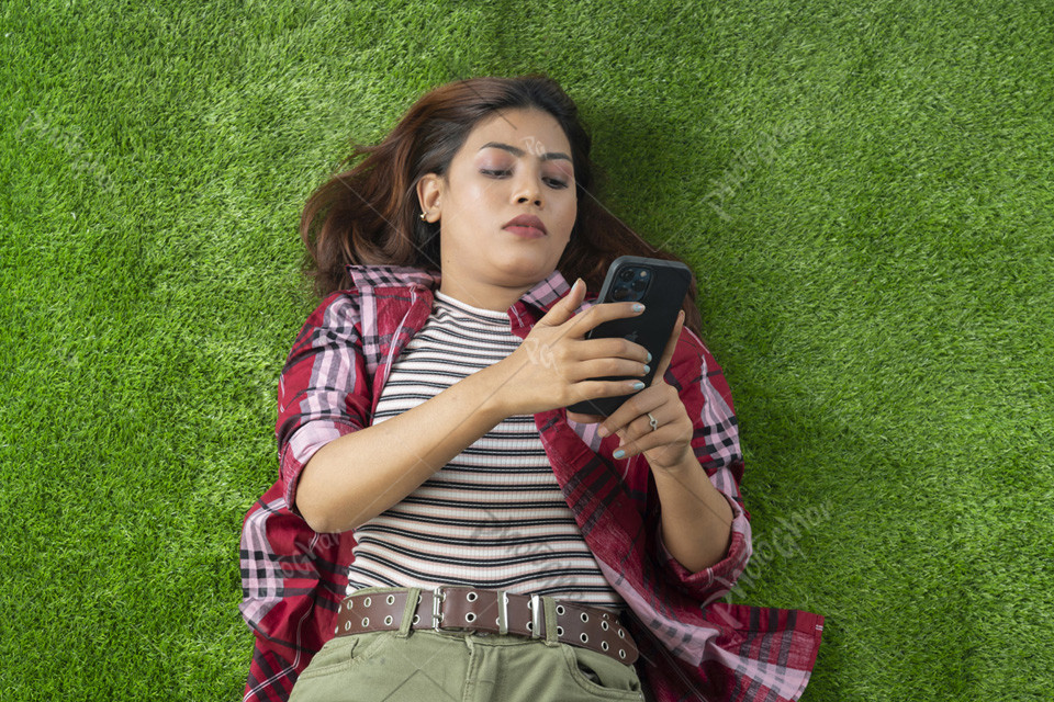 Smartphone using girl lying on grass