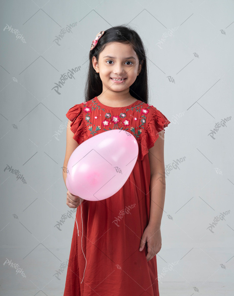 Smiling Baby girl holding balloon