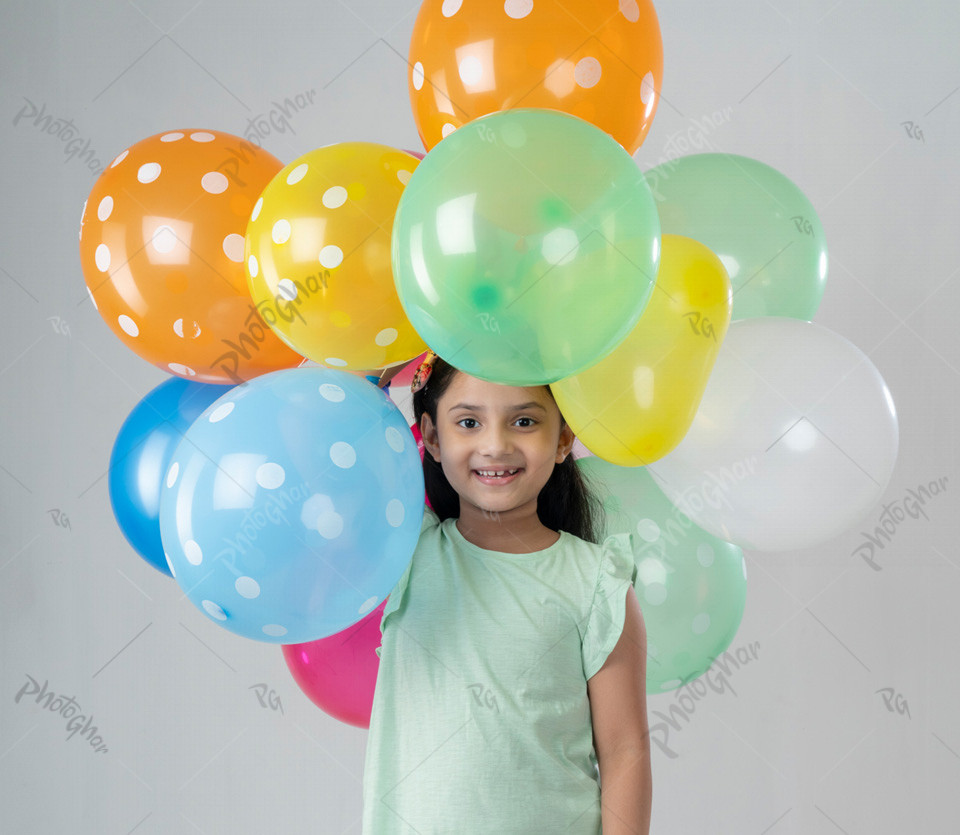 Smiling Beautiful child holding colorful balloons