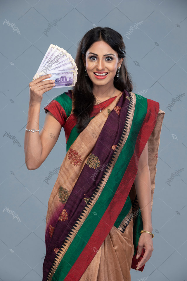 South Asian young happy woman holding money