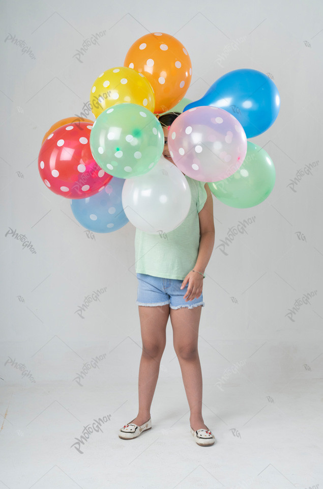 Sweet smiling little girl holding colorful balloon