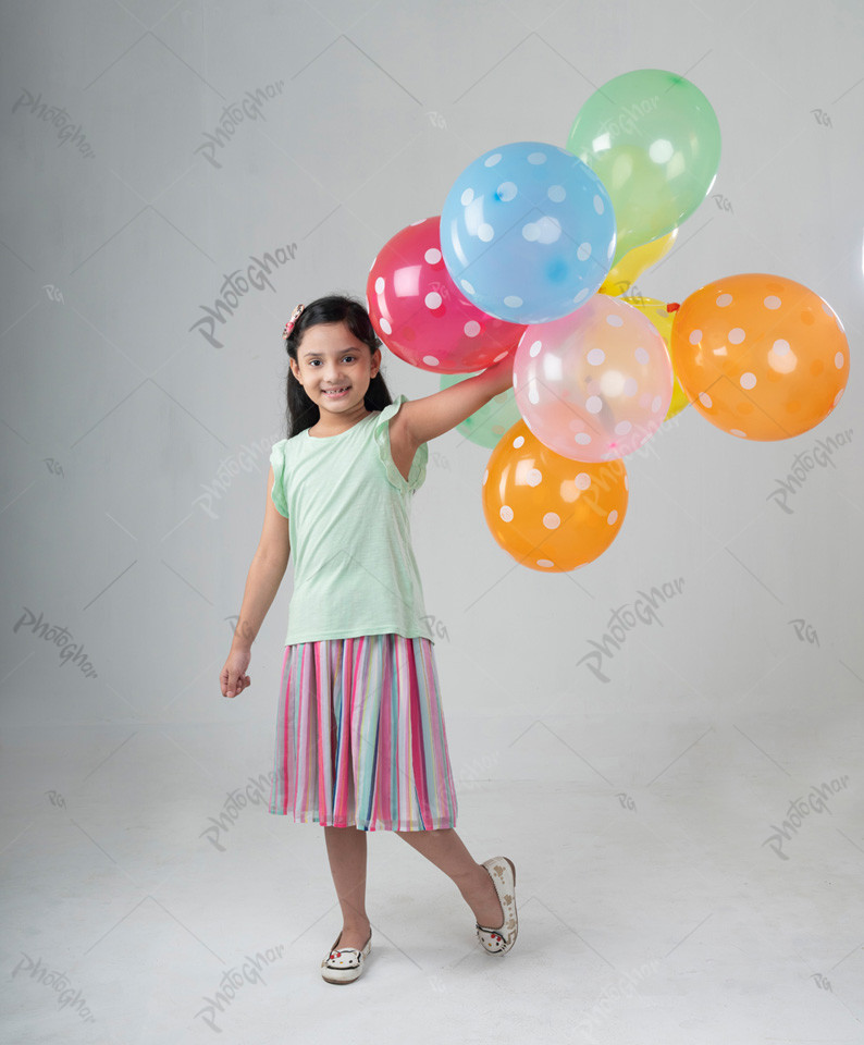 Sweet smiling little girl holding colorful balloon