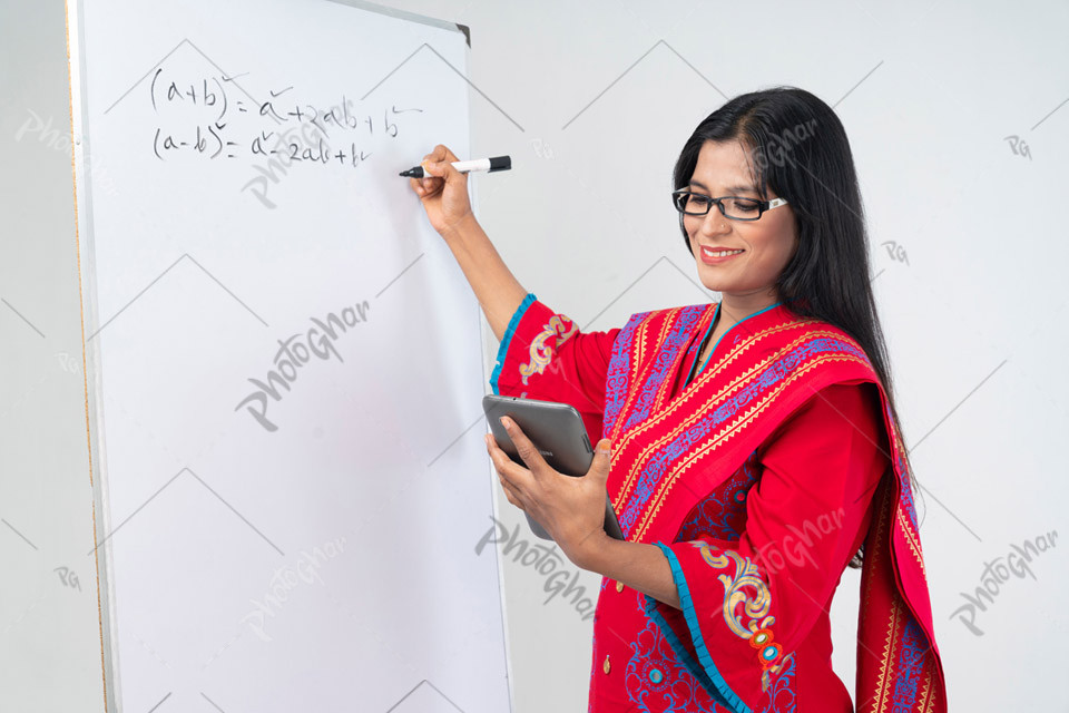 Teacher writing on board with tablet