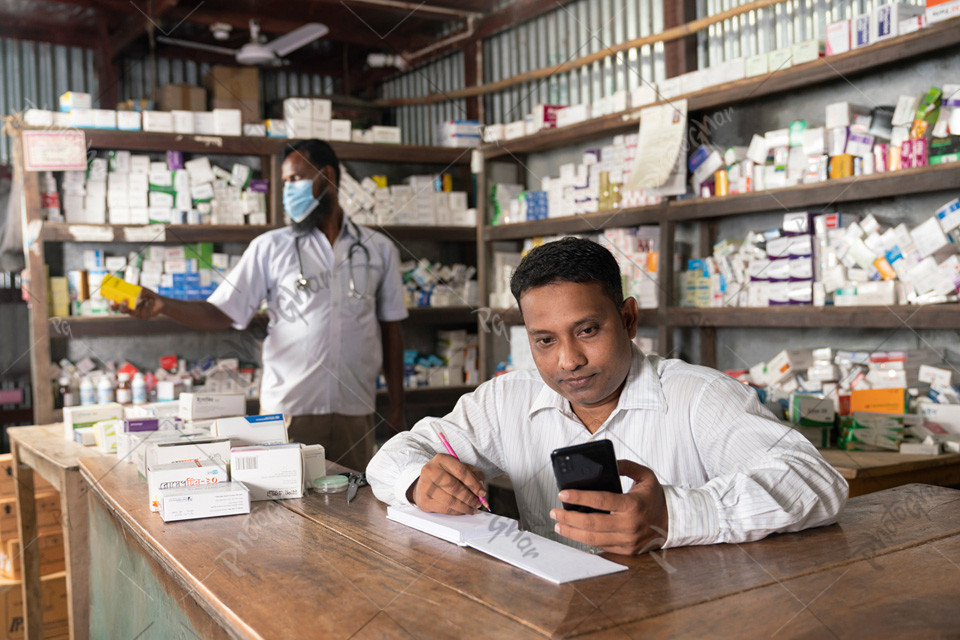 Village pharmacist holding smartphone