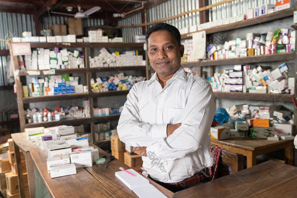 Village pharmacist standing confidently in a Pharmacy