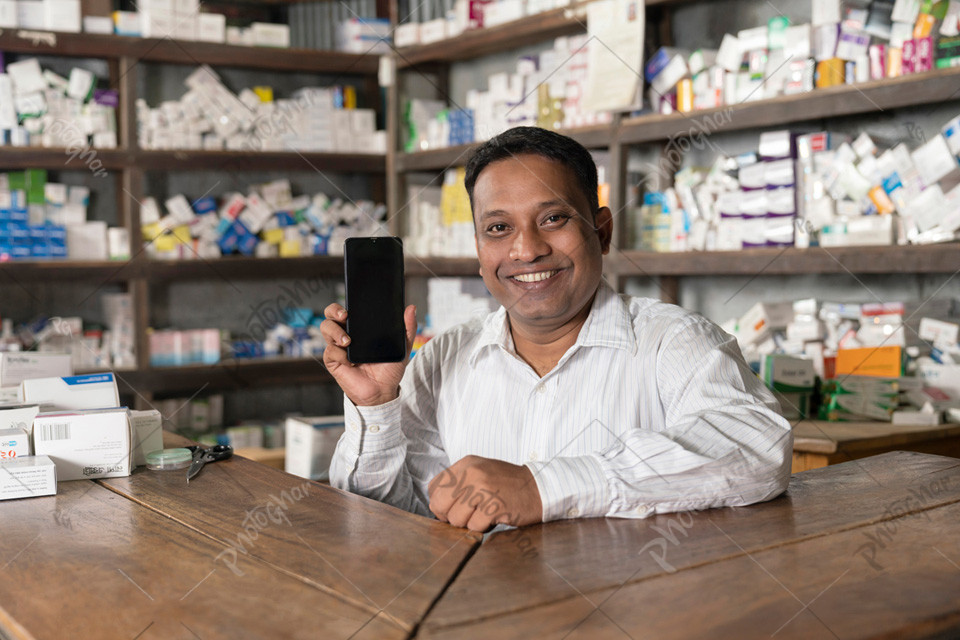 Village pharmacist using mobile to checking online orders