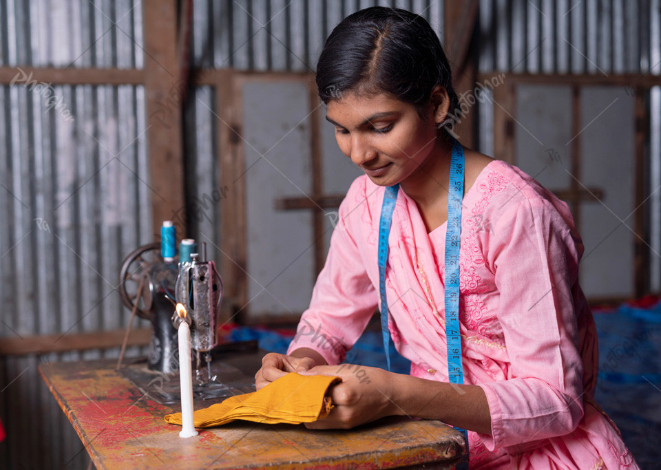 Village rural poor girl of Bangladesh sewing