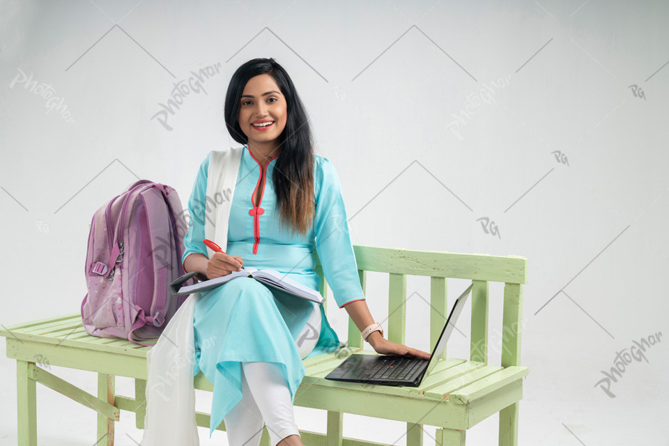 Woman student  studying on bench with Laptop