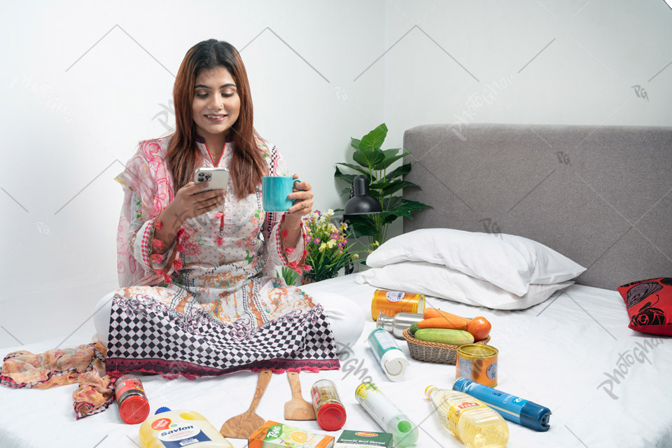 Woman using smartphone and holding coffee mug