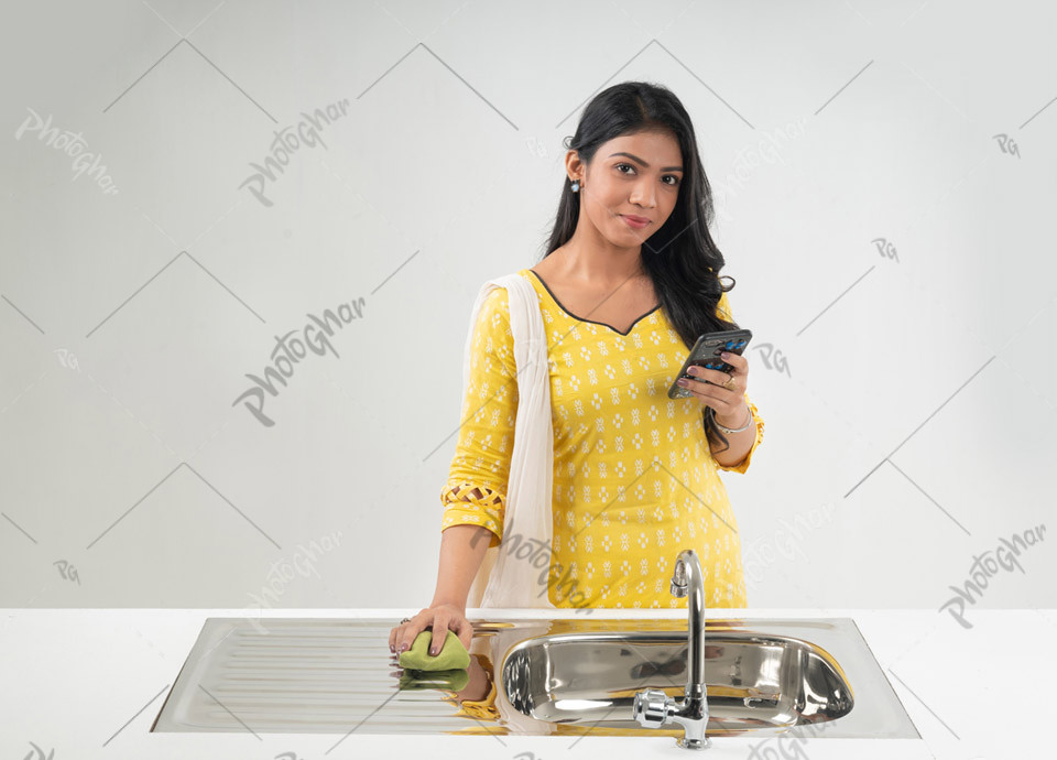 Young adult woman cleaning kitchen sink