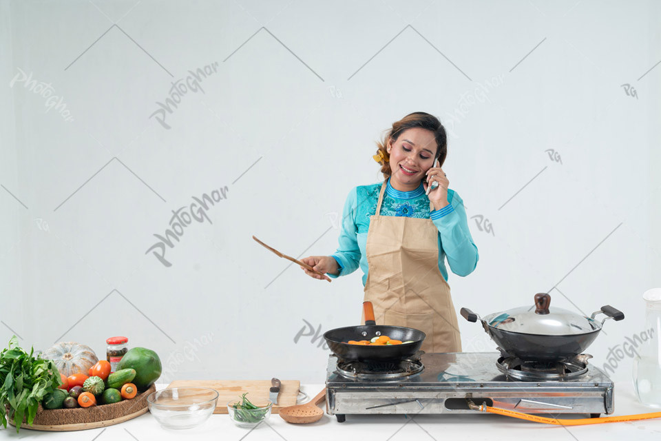 Young lady talking on mobile in kitchen