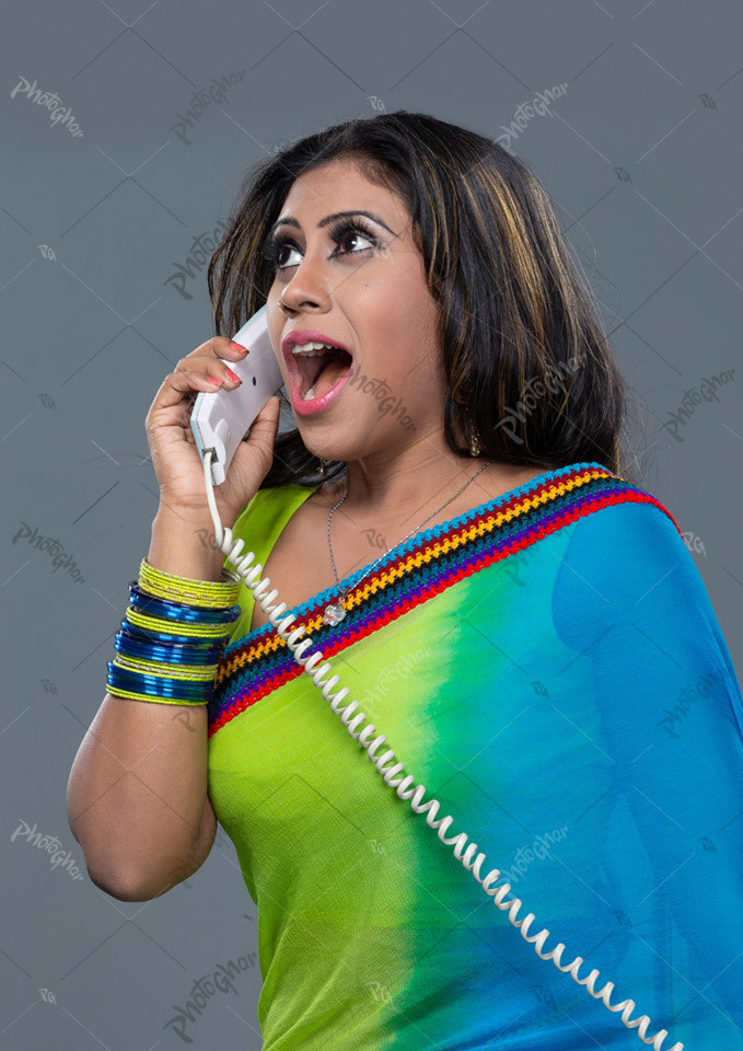 Young shocked woman talking on telephone