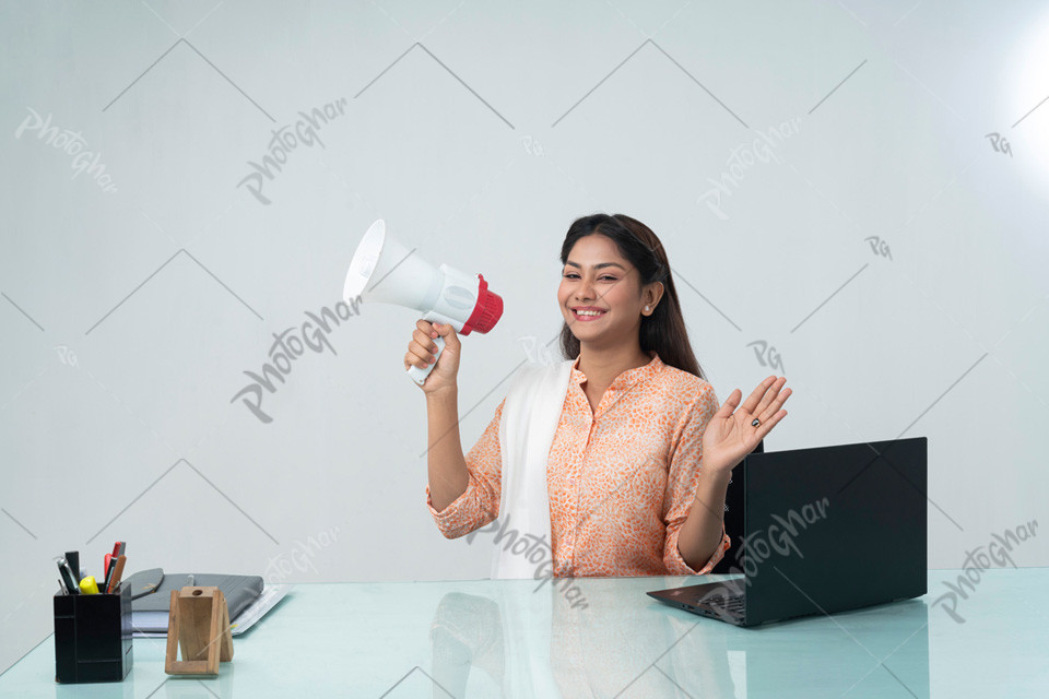 Young smiling businesswoman holding megaphone